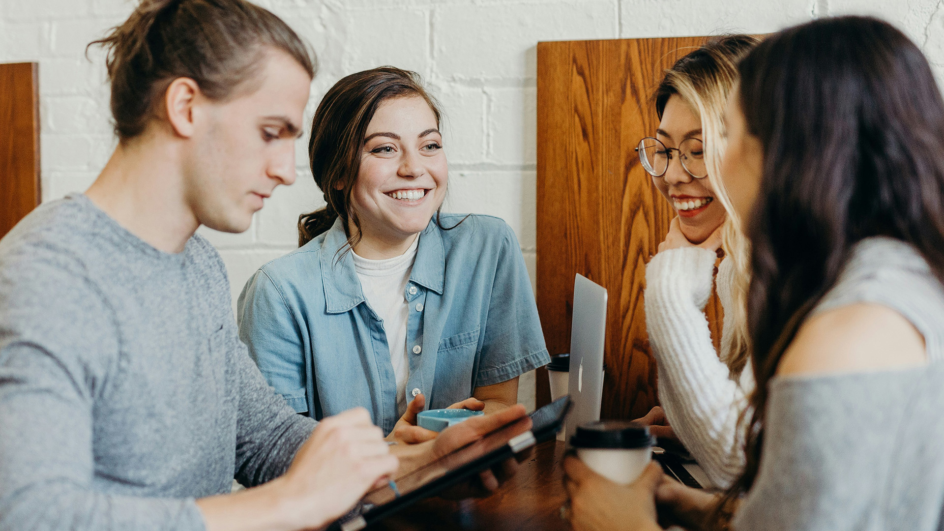 Coworkers laughing and collaborating at a table