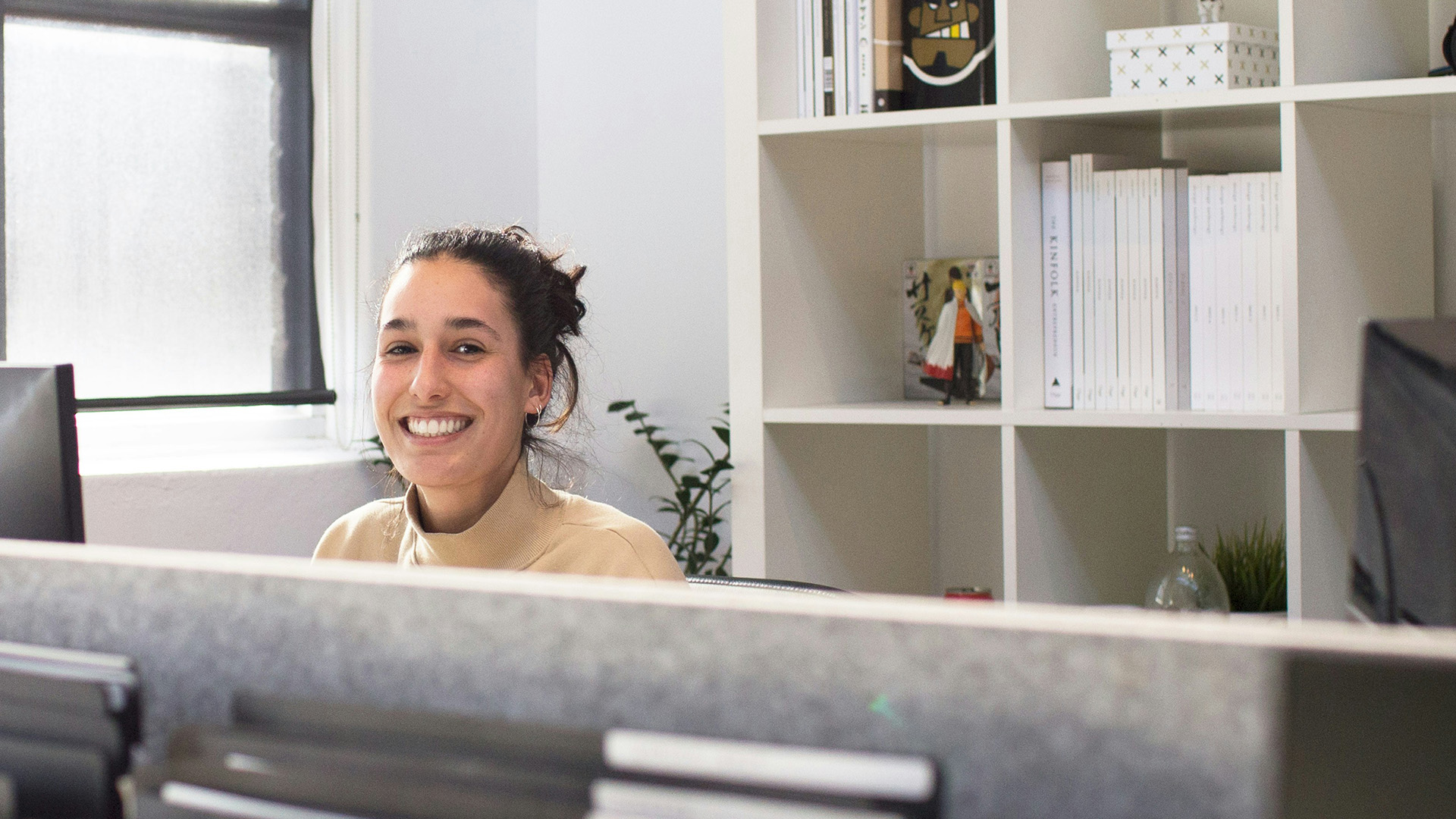 New employee sitting at her work station and smiling