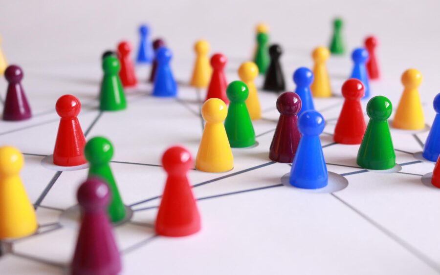 Picture of multicolored game pieces connected on a lined surface to accompany blog on International Networking Week.